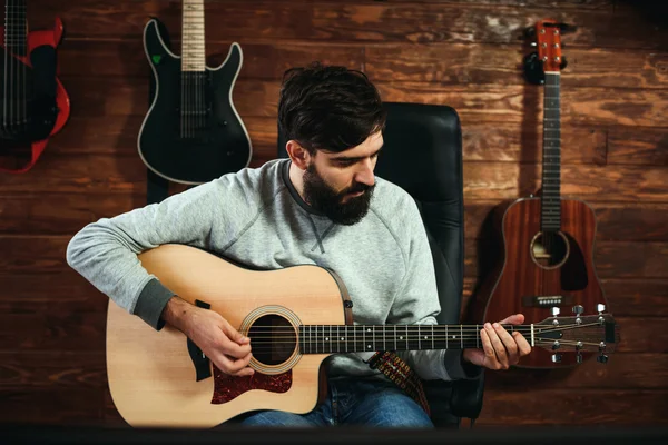 adam gitar çalıyor. Gitar duvar arka planda, aşk müzik konsepti
