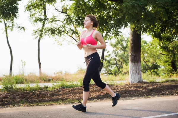 女性を実行します。朝焼けの中ジョギング女性ランナー — ストック写真