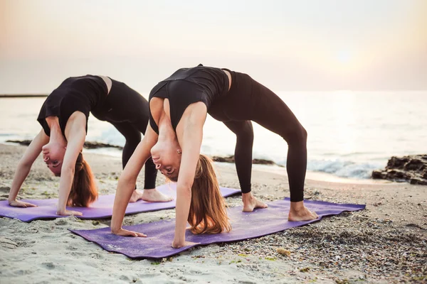 두 젊은 여성이 해변에서 요가 연습 — 스톡 사진