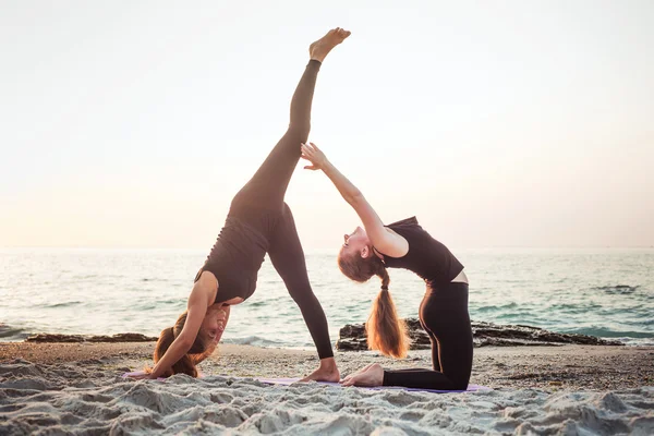두 젊은 여성이 해변에서 요가 연습 — 스톡 사진