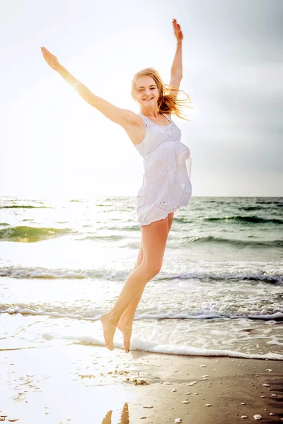 Joven hermosa hembra caucásica disfrutando del sol en la playa al amanecer o al atardecer — Foto de Stock