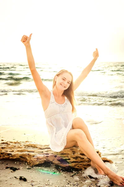 Joven hermosa hembra caucásica disfrutando del sol en la playa al amanecer o al atardecer — Foto de Stock