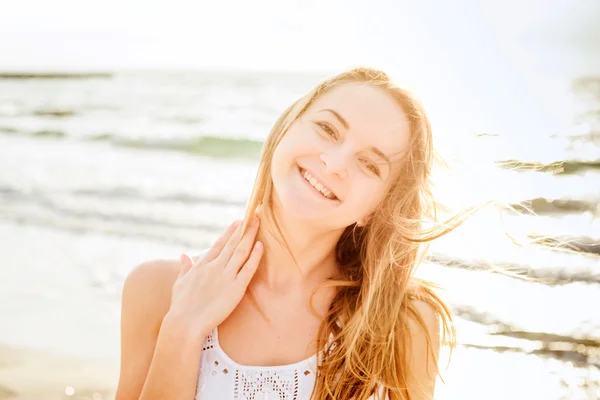 Joven hermosa hembra caucásica disfrutando del sol en la playa al amanecer o al atardecer — Foto de Stock