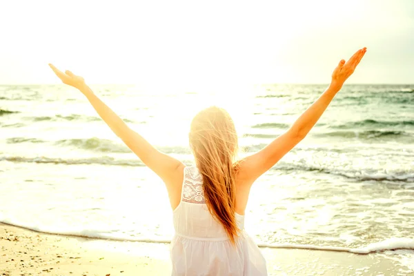 genç güzel beyaz kadın gündoğumu veya günbatımı sırasında plajda güneşin tadını