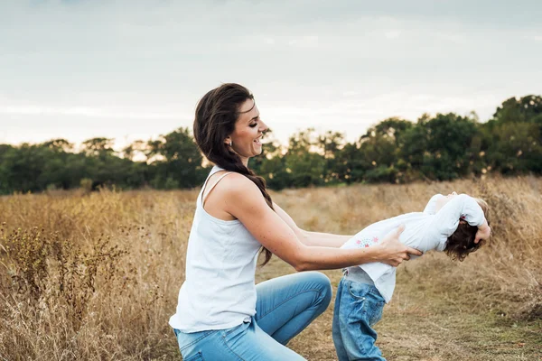 Madre e hija jugando juntos en el campo de otoño, amando a la familia divirtiéndose al aire libre — Foto de Stock