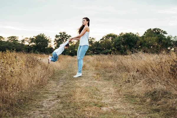 Mãe e filha brincando no campo de outono juntos, amando a família se divertindo ao ar livre — Fotografia de Stock