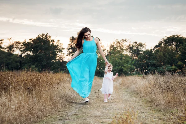 Мать и дочь играют на осеннем поле вместе, любящая семья веселится на открытом воздухе — стоковое фото