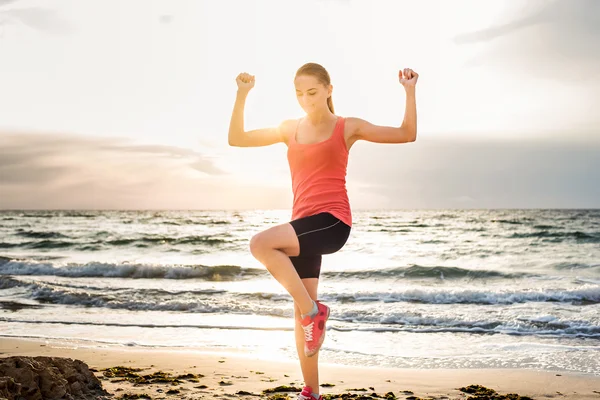 Fitness spor modeli gündoğumu üzerinde açık çalışması sırasında egzersizleri yapıyor. Güzel beyaz kadın eğitim dışında sahil sabah — Stok fotoğraf