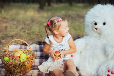 küçük kız Park ayı oyuncak ve elma ile eğleniyor