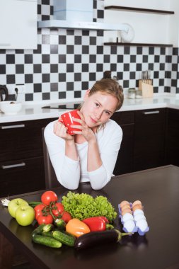 masaya içme kahve veya çay mutfak, taze meyve ve sebze genç beyaz kadın. O sabah onu sağlıklı kahvaltı ile başlar
