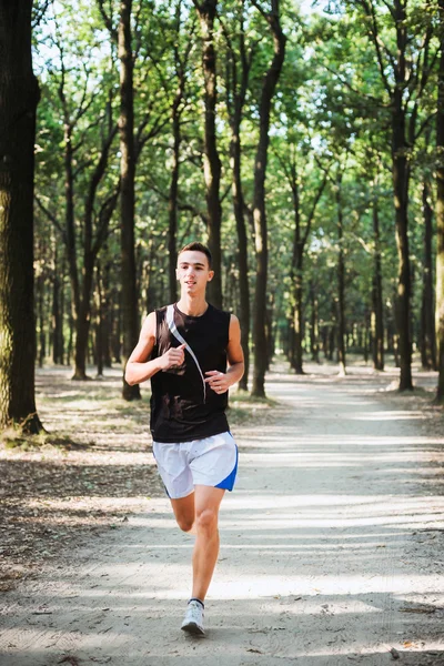 Jovem caucasiano macho correndo no parque. Jogging adolescente no parque — Fotografia de Stock