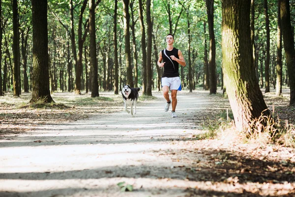 犬でうまきます。シベリアの胡主席と実行する若い白人男性 — ストック写真