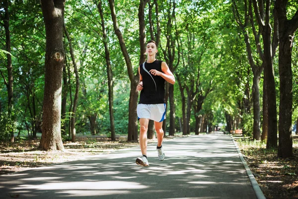 若い白人男性が公園で実行します。10 代の公園でジョギング — ストック写真