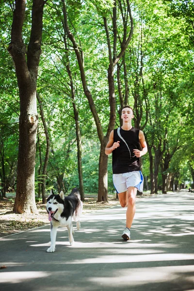 work out with dog. Young caucasian male running with siberian hu