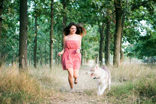 Giovane bella formazione femminile caucasica con cucciolo husky siberiano nel parco — Foto Stock