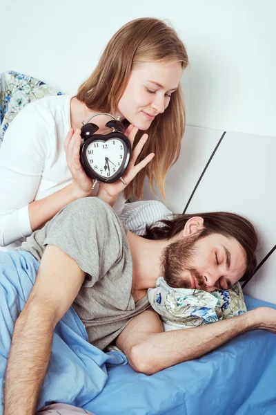 알람 시계와 함께 침대에 젊은 백인 부부 — 스톡 사진