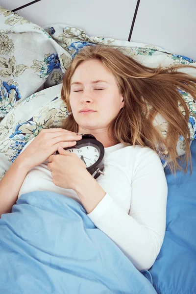 침대에서 알람 시계와 함께 젊은 백인 여성 — 스톡 사진