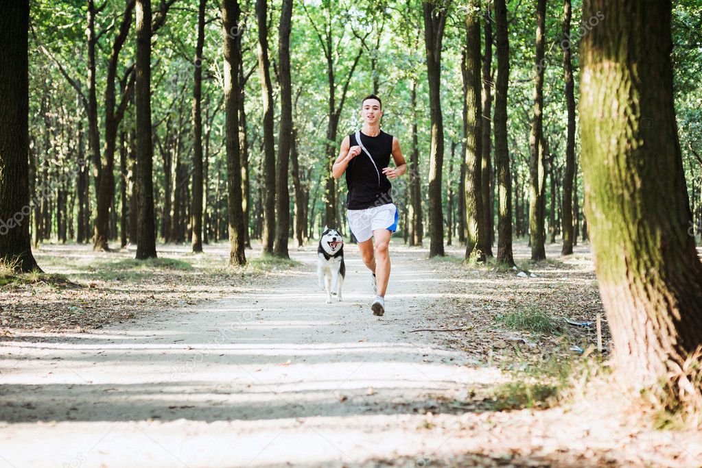 work out with dog. Young caucasian male running with siberian hu