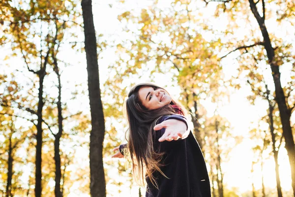 Giovane donna felice con le mani allegre nel parco. Donna che si gode il sole autunnale — Foto Stock