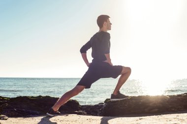 Kumsalda, sportif adam egzersizleri yapıyor çalışma dışarı genç erkek