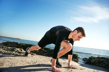 Kumsalda, sportif adam egzersizleri yapıyor çalışma dışarı genç erkek