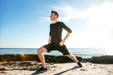 Kumsalda, sportif adam egzersizleri yapıyor çalışma dışarı genç erkek