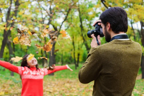 Joven feliz pareja tomando fotos en el parque de otoño — Foto de Stock