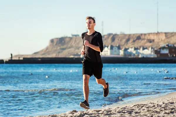 L'homme qui court. Coureur homme jogging pendant le lever du soleil sur la plage — Photo