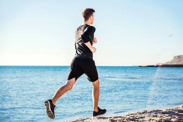 Kolejny człowiek. Mężczyzna runner joggingu podczas słońca na plaży — Zdjęcie stockowe