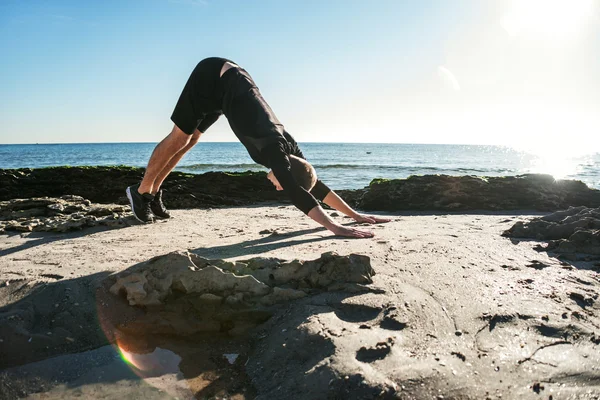 Junger Mann trainiert am Strand, sportlicher Mann macht Übungen — Stockfoto