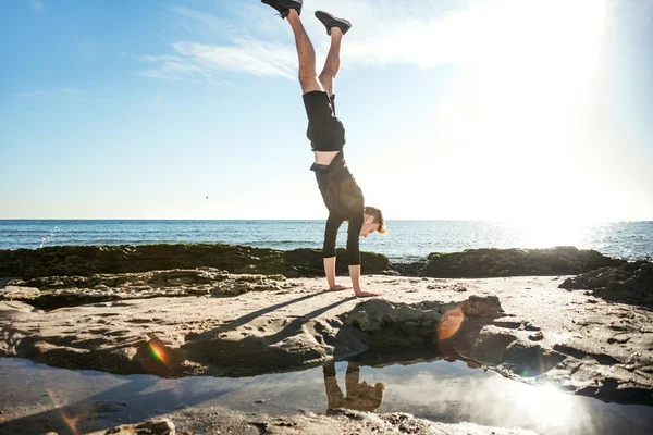 Junger Mann trainiert am Strand, sportlicher Mann macht Übungen — Stockfoto