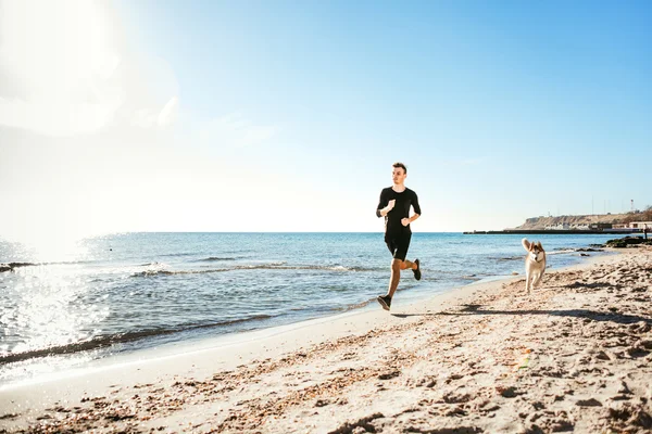 Laufmann. Läufer joggen während des Sonnenaufgangs am Strand — Stockfoto