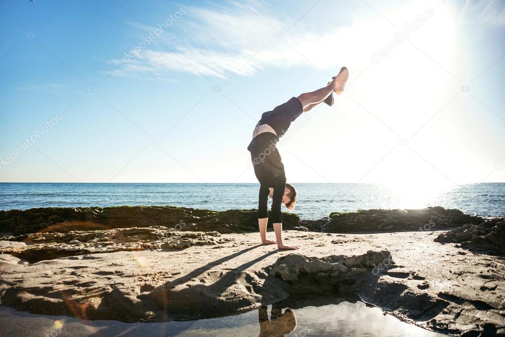 young male working out on beach, sporty man doing exercises