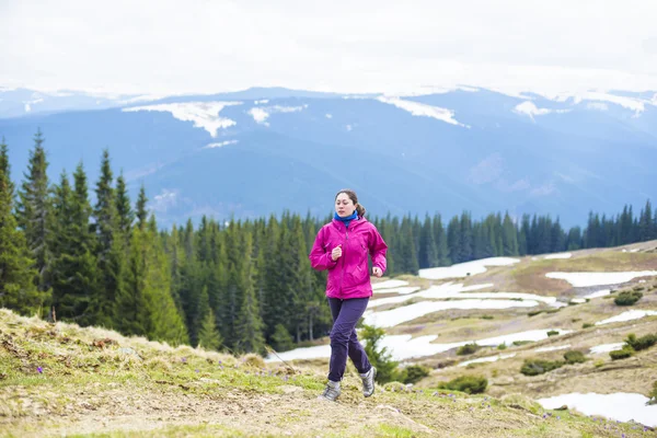 Female running athlete. Woman trail runner sprinting for success goals and healthy lifestyle in amazing nature landscape.