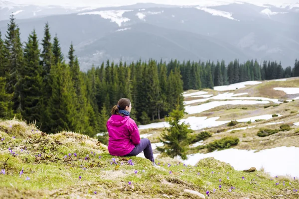 Young caucasian woman sitting and enjoying the view in mountains — Stock Photo, Image