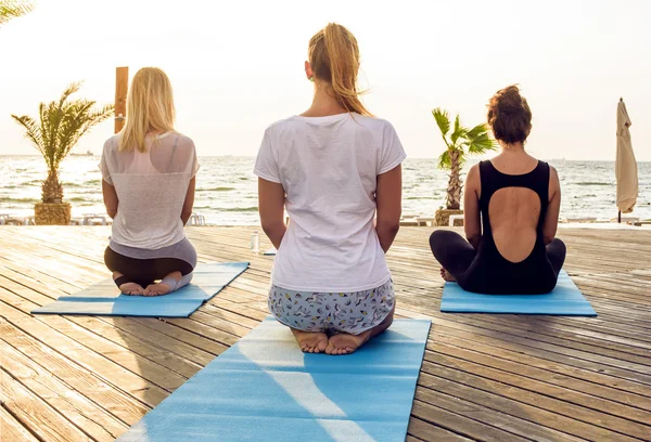 Samice praktykowania jogi nad morzem — Zdjęcie stockowe