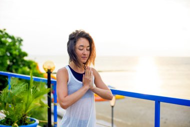 pratik Yoga sahilde gündoğumu sırasında genç beyaz kadın