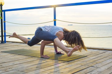 pratik Yoga sahilde gündoğumu sırasında genç beyaz kadın
