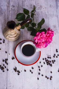 kahve fincanı, kahve çekirdekleri ve gül ahşap arka plan üzerinde