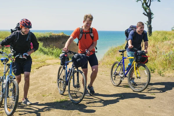 Young cheering  caucasian bicyclists on the seaside — Stock Photo, Image