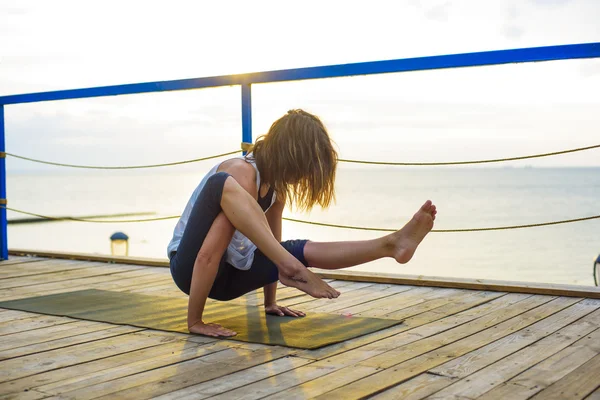 Młody kaukaski kobieta praktykowania jogi na plaży podczas sunrise — Zdjęcie stockowe