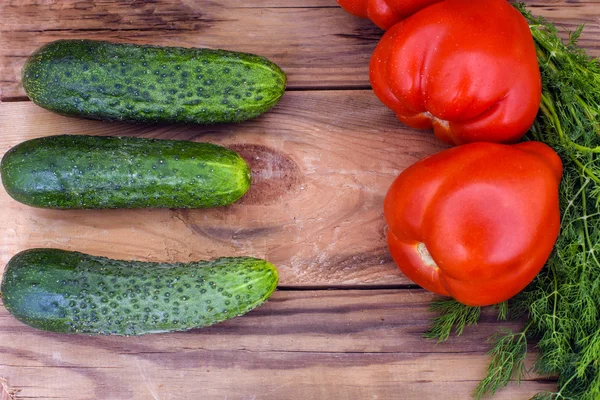 Fresh vegetables, cucumbers, tomatoes and fennel on wooden background — Stock Photo, Image