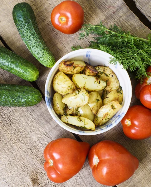 Homemade food, fried potatoes, tomatoes, cucumbers and fennel on wooden table — Stock Photo, Image
