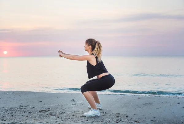 Fitness spor modeli mutlu gülümseyerek gündoğumu açık çalışma sırasında egzersizleri yapıyor. Güzel beyaz kadın eğitim dışında sahil sabah — Stok fotoğraf