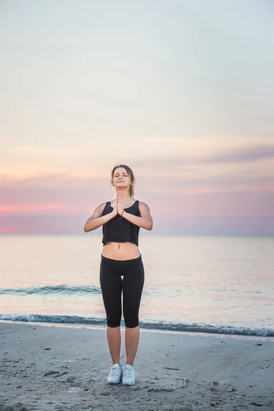 Modello di sport fitness sorridente felice facendo esercizi durante il lavoro all'aperto all'alba. Bella formazione femminile caucasica al di fuori sul mare al mattino — Foto Stock