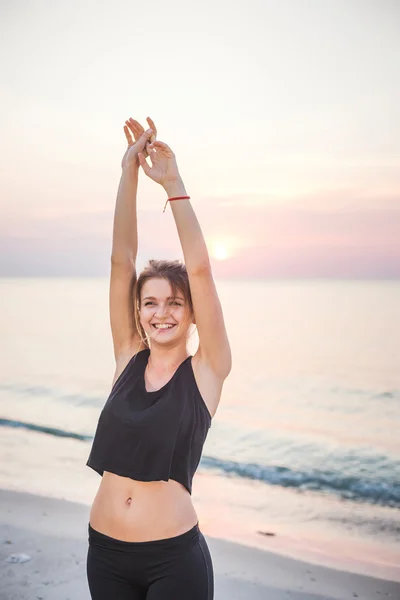 Fitness spor modeli mutlu gülümseyerek gündoğumu açık çalışma sırasında egzersizleri yapıyor. Güzel beyaz kadın eğitim dışında sahil sabah — Stok fotoğraf