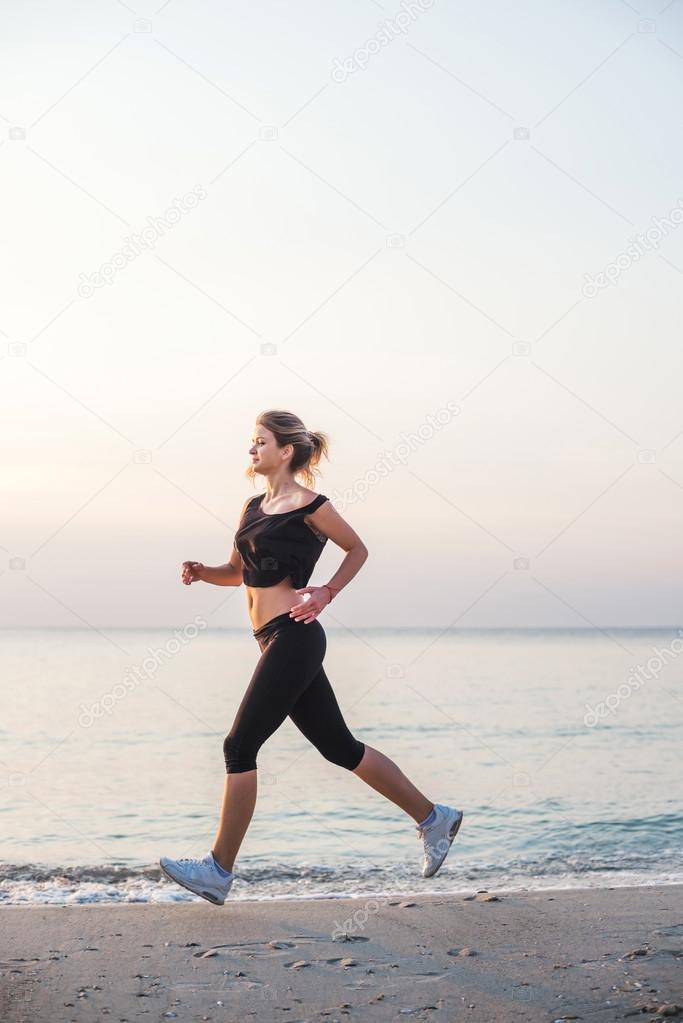 Running woman. Female runner jogging during the sunrise on beach.