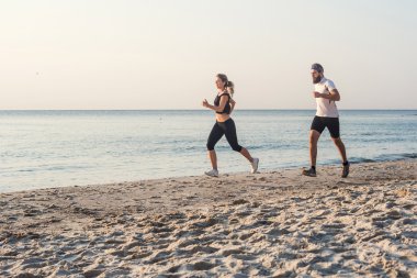 Kadın ve adam sahilde koşu