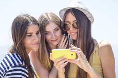 Üç kız bir deniz cep telefonu kamera kendi kendine portre yapma