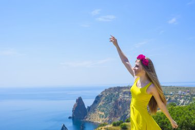 uçurumdan denizden üzerinde canlı sarı elbiseli genç güzel beyaz kadın